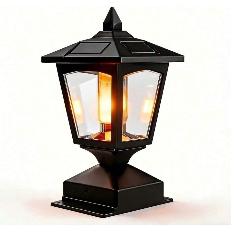 Solar post cap lantern glowing warm amber on outdoor fence post.