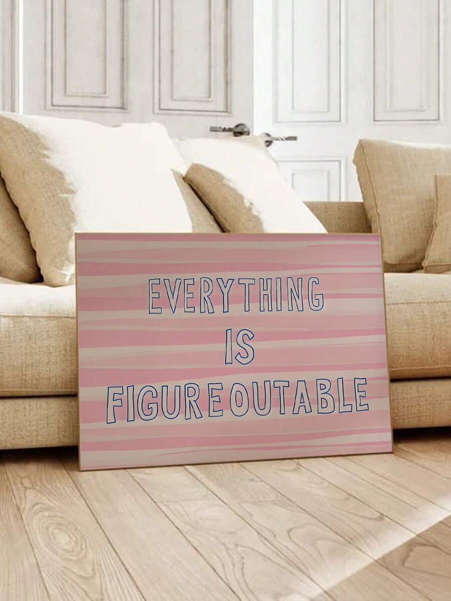Pink striped Everything Is Figureoutable framed quote wall art beside sofa