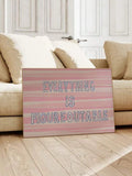 Pink striped Everything Is Figureoutable framed quote wall art beside sofa