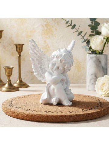 European white angel tabletop decor with seated cherub and raised feathered wings.
