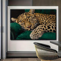 Realistic leopard animal portrait print with gold fur and black spots on green sofa