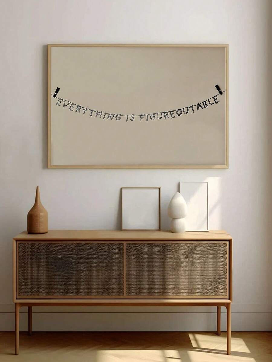 Quote wall art over console with Everything is figureoutable text and light wood frame