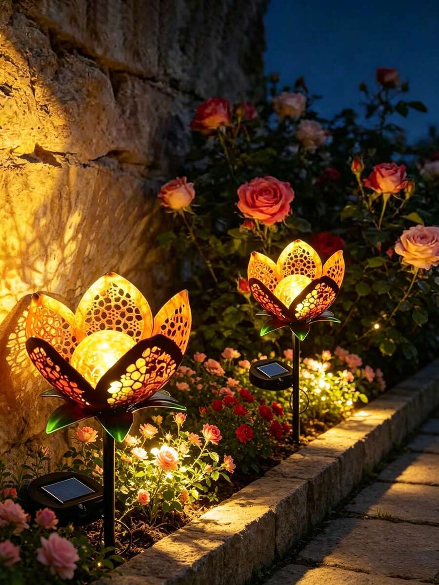 Solar flower light pair glowing in rose bed with amber petals and crackle glass globes