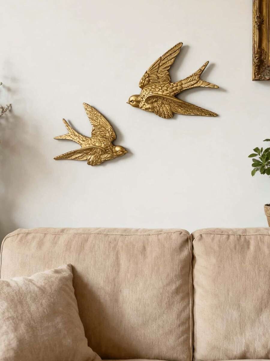 Close-up of glossy gold bird decor with dark recessed grooves and textured feathers.