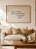 Black script quote poster displayed over a neutral sofa and cushions