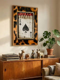 Ace card poster wall mounted above cabinet with plants records and maximalist decor