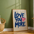 Love You More quote poster against olive wall beside rattan chair