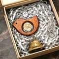 Bird wind chime shown outdoors under roof with crystal and metal bell.