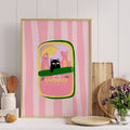 Gold framed cat sardines poster on kitchen counter
