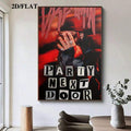 Wall-hung PartyNextDoor poster above a modern dining table beside a tall window