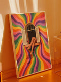 Large white framed rainbow swirl window poster leaning on orange floor and wall in warm sunlight