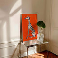 Bold orange dog poster on shelf with books and decor