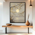Black framed moonlit lake and branch wall art above console shelf with wood vase and pendant light