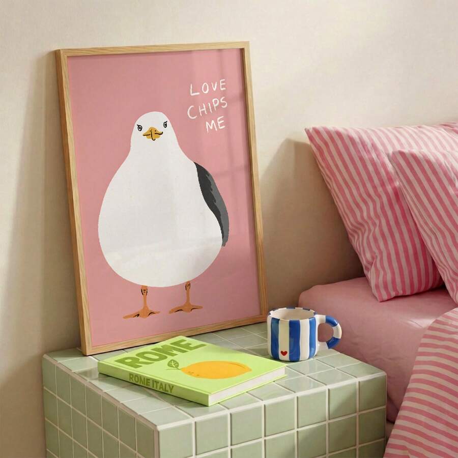 Framed funny bird wall art leaning on shelf in soft pastel room