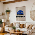 Large funny poop typography poster with blue cartoon face hanging above boho cream sofa