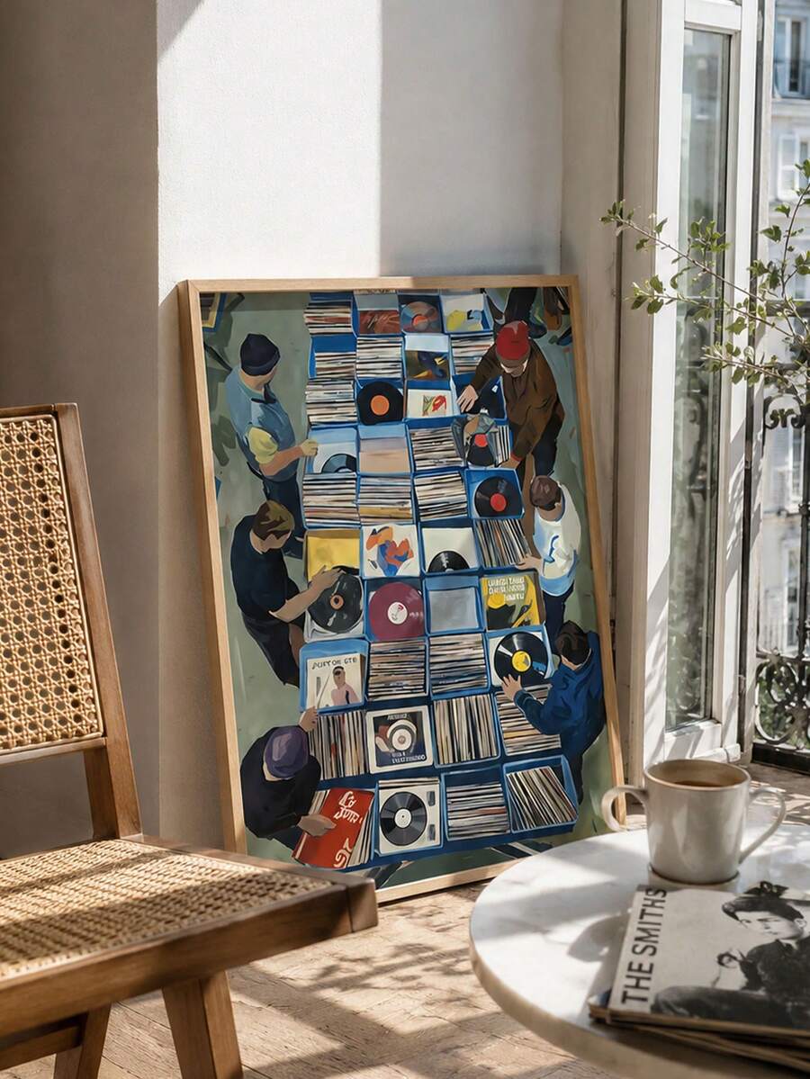 Framed vinyl market wall art leaning beside record cabinet speaker and turntable in cozy music room