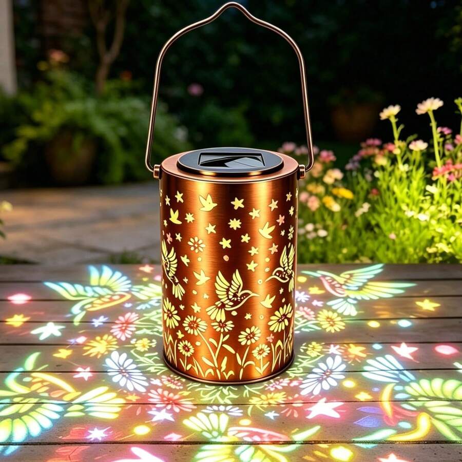 Solar hummingbird lantern projecting warm floral bird patterns outdoors.