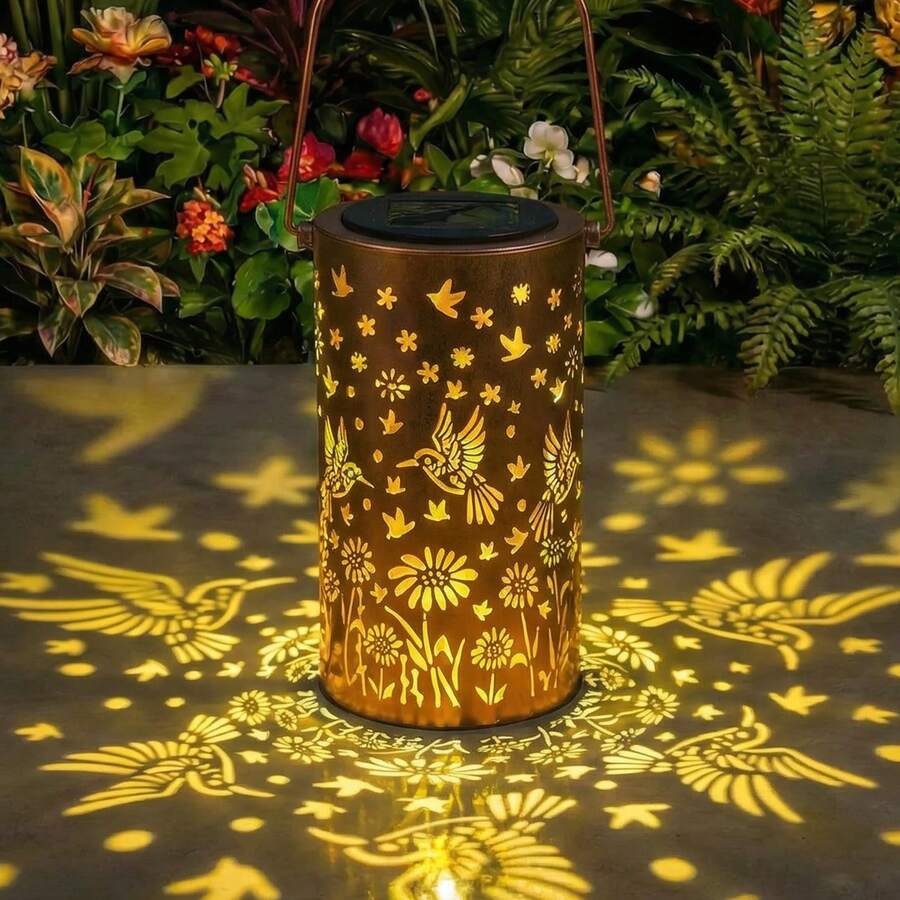 Solar metal lantern detail showing warm LED glow and perforated floral pattern.