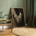 Gothic skeletal hands holding in a wood-framed portrait print in a green room