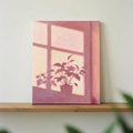 Close view pink plant window wall art leaning on wood shelf