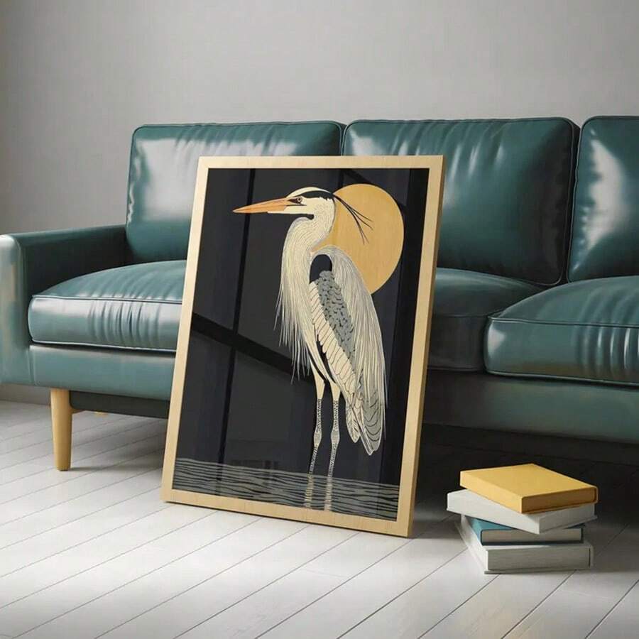 Framed heron wall art leaning on floor in sunlit room with plant and radiator