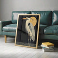 Heron bird print in light frame leaning against teal leather sofa