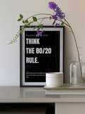 Black 80 20 rule motivational poster in black frame with vase and purple flowers on shelf