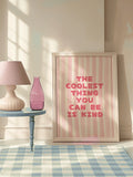 Pink typography canvas poster in a white frame near a sofa