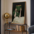 Gold framed reading woman poster on console