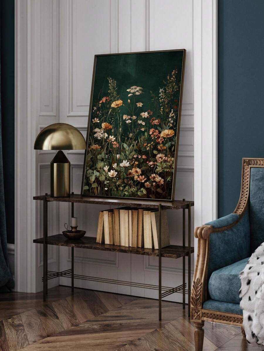 Framed dark green wildflower botanical print leaning on console in gallery wall setting