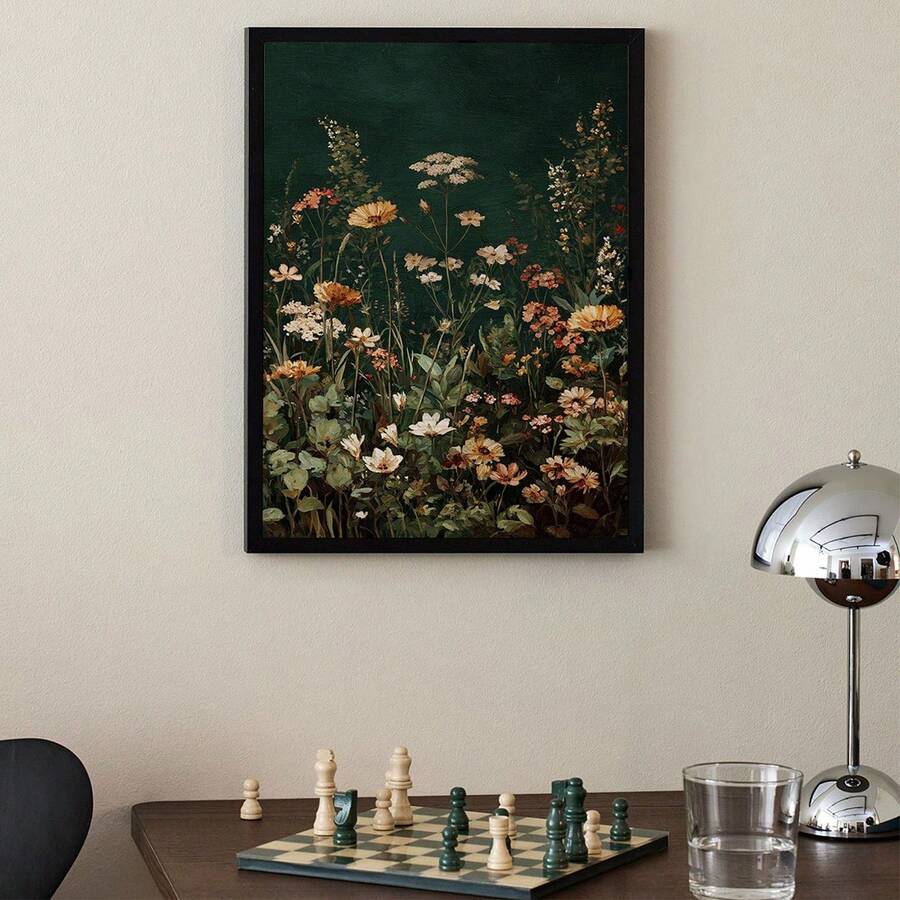 Black framed dark green floral wall art above desk with chess board and chrome lamp