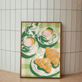 Cafe wall art with playful tea cup poster and light wood frame styling