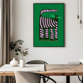 Framed whimsical black cat print on green background in dining room