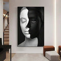 Black-framed split-tone woman portrait canvas print in a modern hallway with ottomans