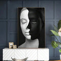Gold-framed woman portrait canvas print on a navy accent wall above a white credenza