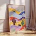 Bright abstract cactus print in wood frame leaning against wall