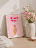 Framed Trust Your Magic affirmation artwork beside pink flowers