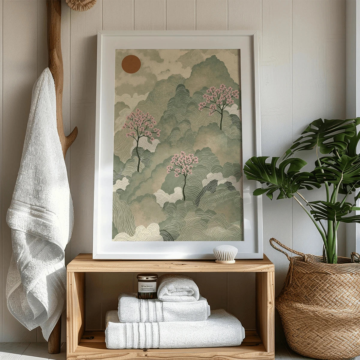 Japanese landscape print in a white frame beside wood shelving and greenery