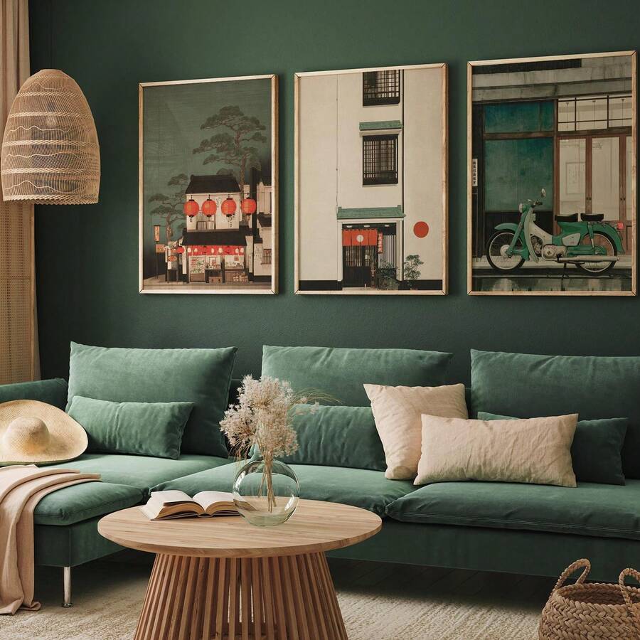 Framed Japanese street art triptych above a green sectional sofa