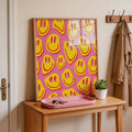 Pink smiley face poster in wood frame on console