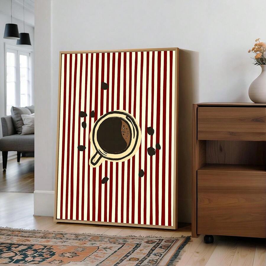 Framed coffee cup and beans print with red stripes near wood cabinet