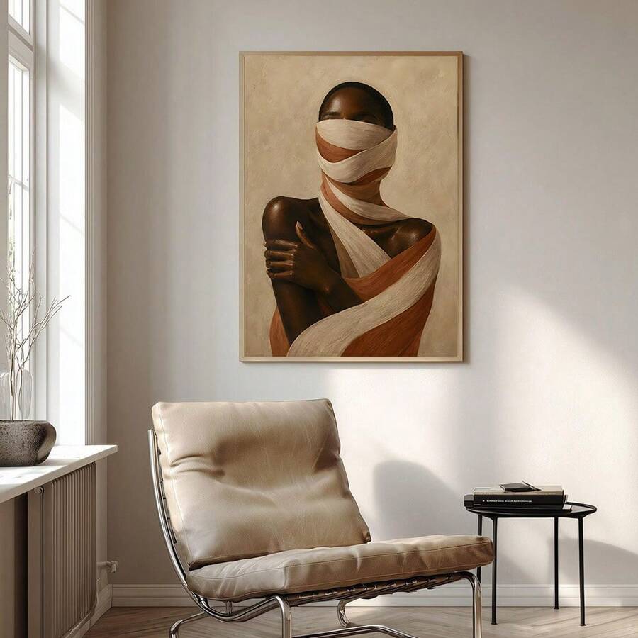 Framed portrait of woman wrapped in cream and terracotta fabric above beige sofa with neutral pillows