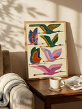 Colorful heron print leaning beside chair and plant in warm room setting
