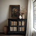 close-up artwork detail of Dark academia still life wall art showing stacked antique books, roses, lit taper candles, warm gold tones and moody Victorian library styling.