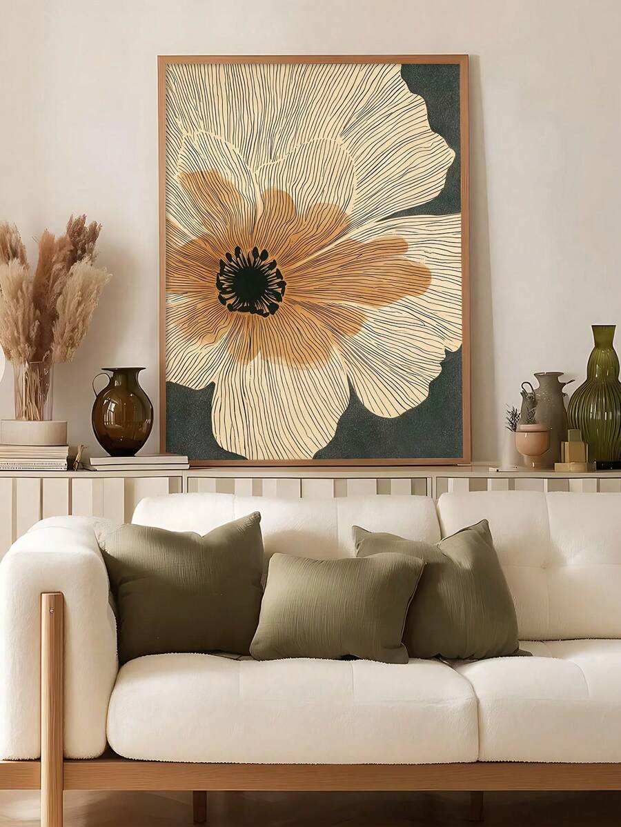 Beige floral line art in a brown frame beside a neutral sofa
