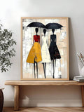 Three stylized women under black umbrellas in a wood-framed vertical fashion print on a console table