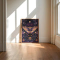 Small framed mystical moth wall art displayed in sunlit cream interior
