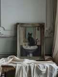Vintage framed cat artwork with gold mirror and white sink