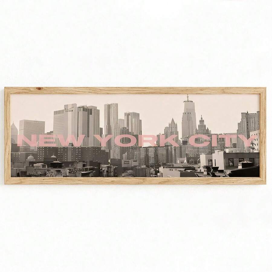 canvas option view of Panoramic framed wall art showing a black and white New York City skyline photo with blush pink NEW YORK CITY typography and modern travel poster style.