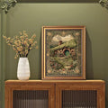 Framed cottagecore wall art with moss green tones and cozy garden scene